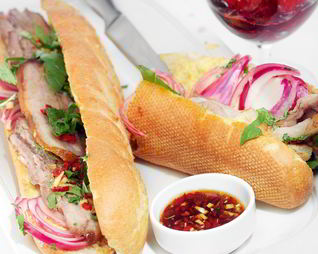 Сэндвич на маленьком багете со свиной брюшиной и маринованным луком